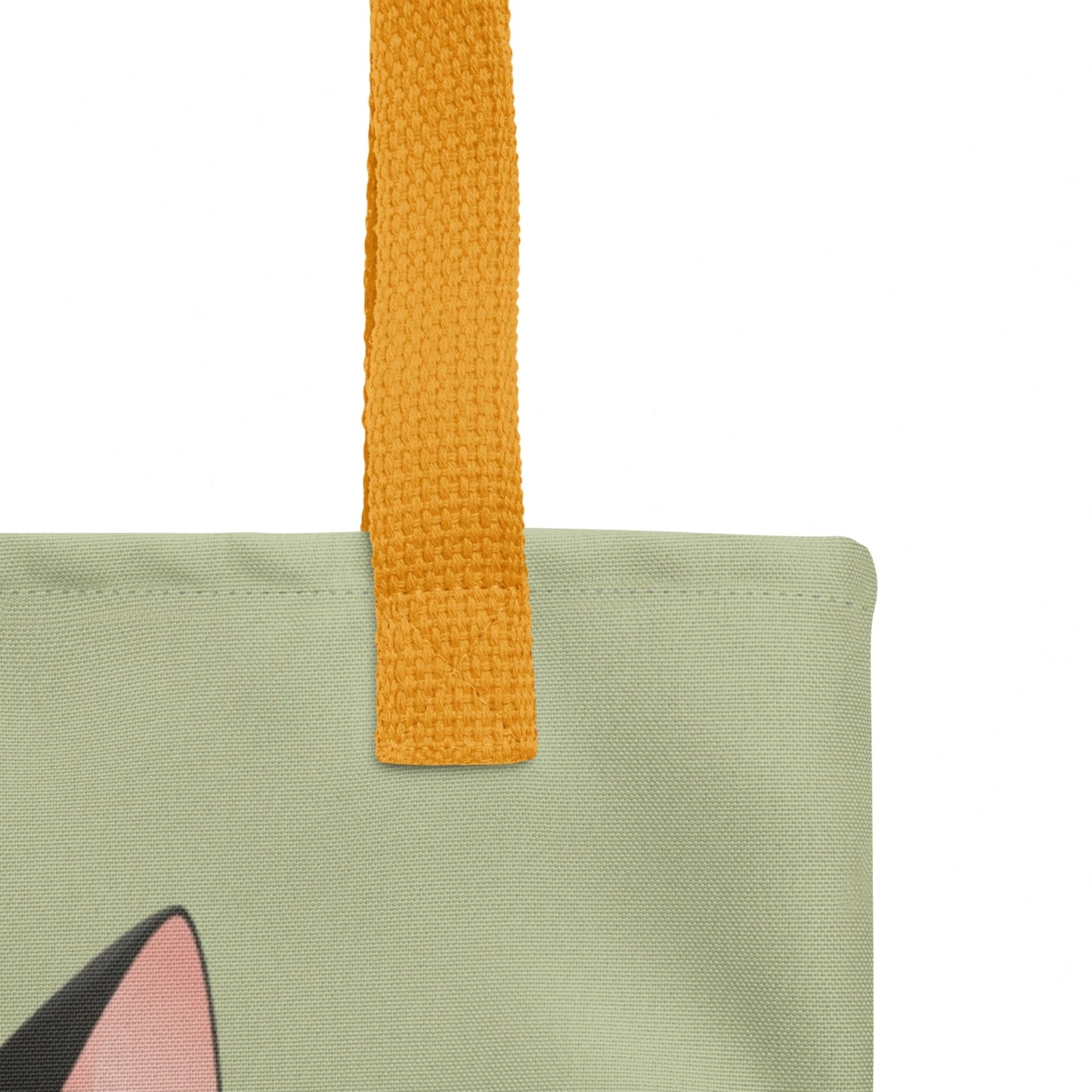 Detailed close-up of Alfred tote bag strap stitching and top edge, cat design visible on a sage green background