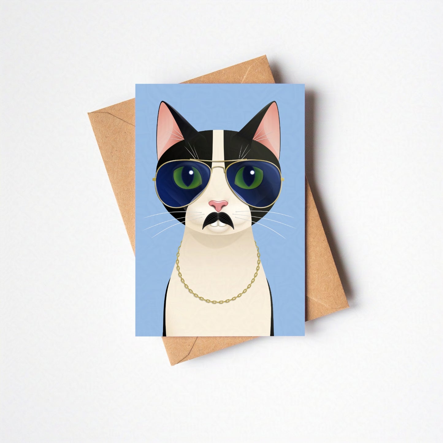 Overhead view of Freddie greeting card and envelope laid flat, featuring the cat against a blue-coloured card background on a neutral backdrop