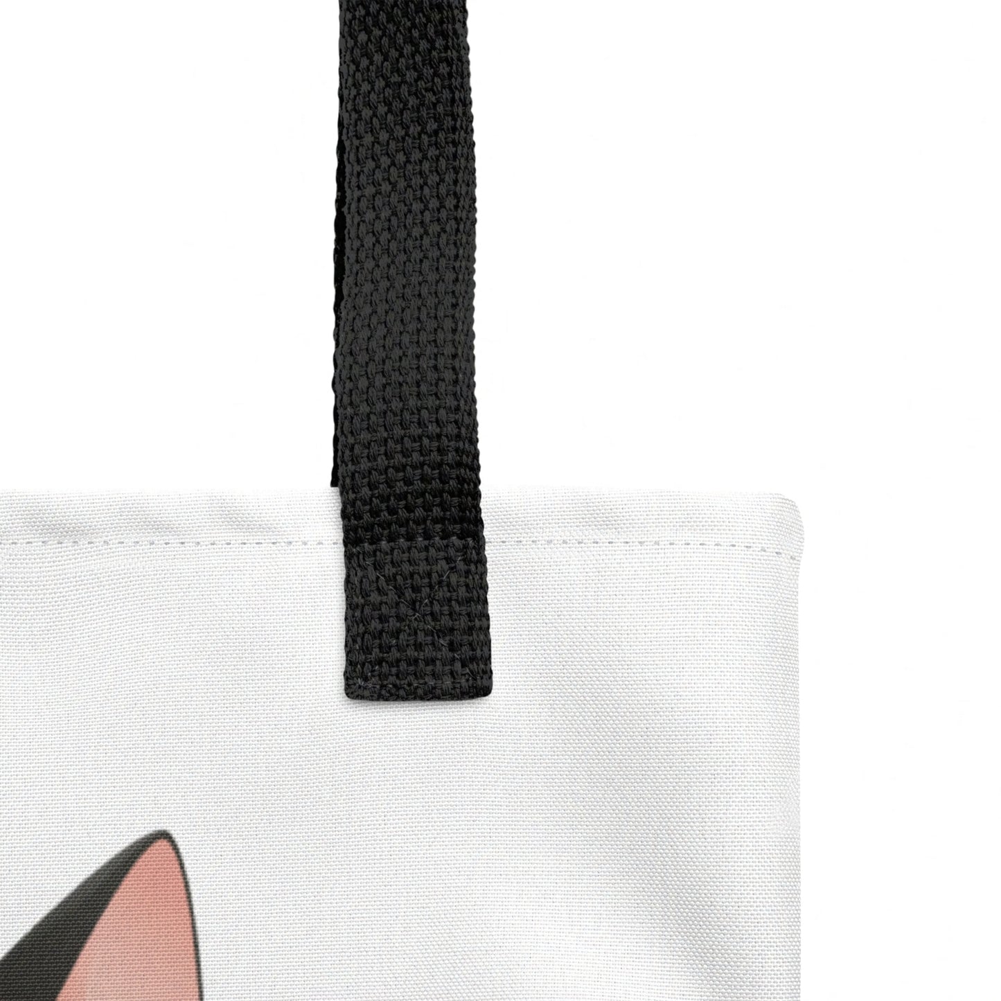 Close-up detail of Freddie tote bag strap join and stitching, cat print visible below against a white background