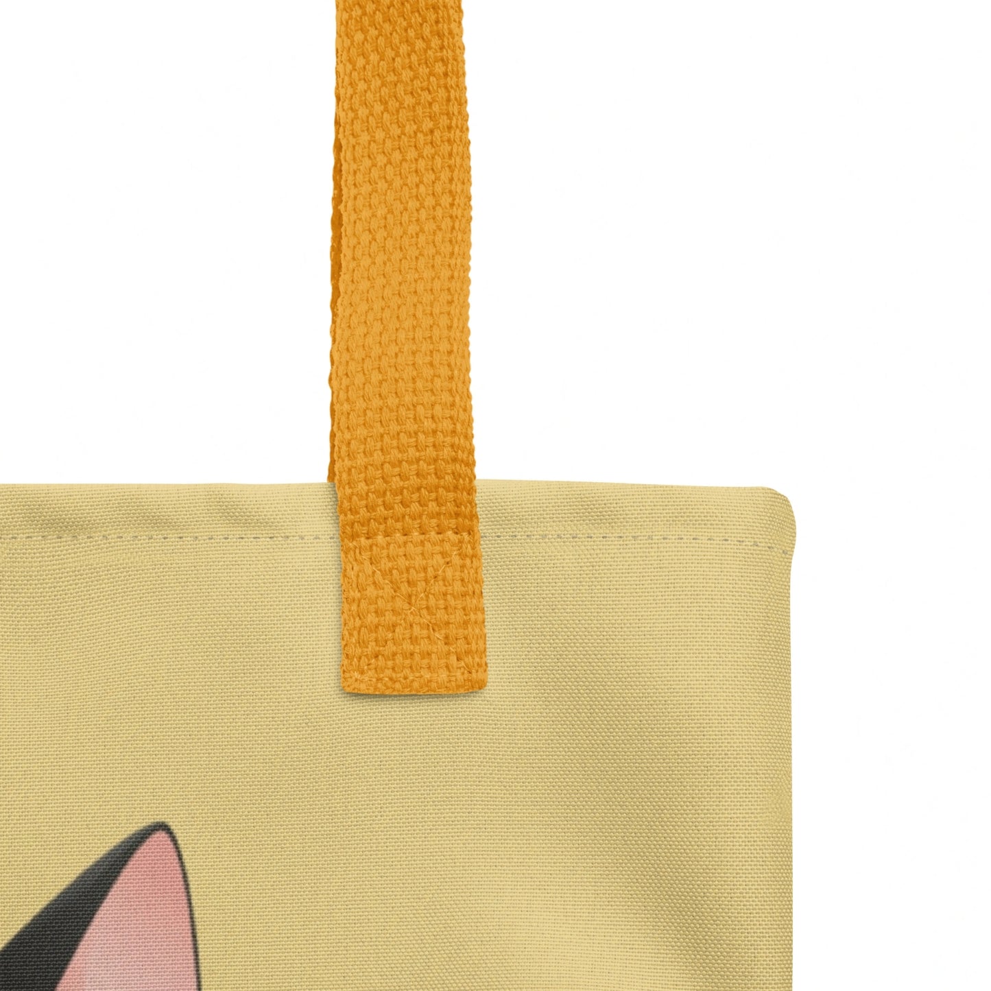 Detailed close-up of tote bag strap stitching and top edge, with part of Mr Cat’s design visible on a yellow background