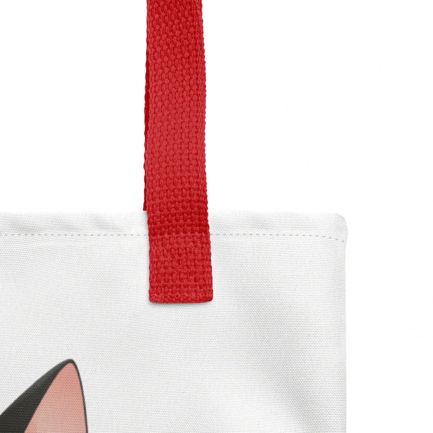 Close-up of tote bag strap join, highlighting sturdy stitching and the Smudge cat print against a white background.