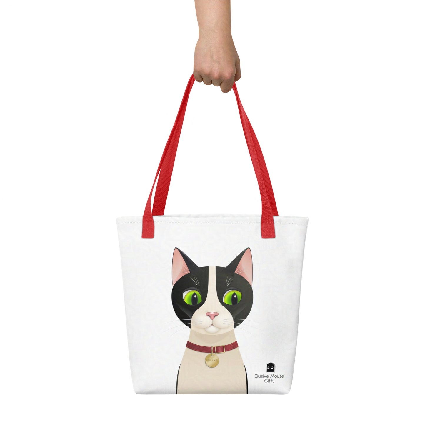 ote bag with Smudge cat design, shown being held by hand against a white backdrop for scale and lifestyle context