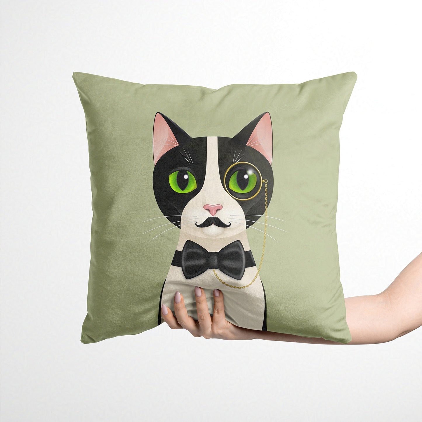 Green cushion with a cat design held by a hand against a white background