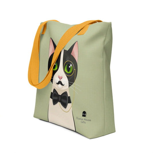 Tote bag featuring Alfred the tuxedo cat in a monocle, fake moustache and black bow tie, shown from a stylish 3/4 angle on a sage green background