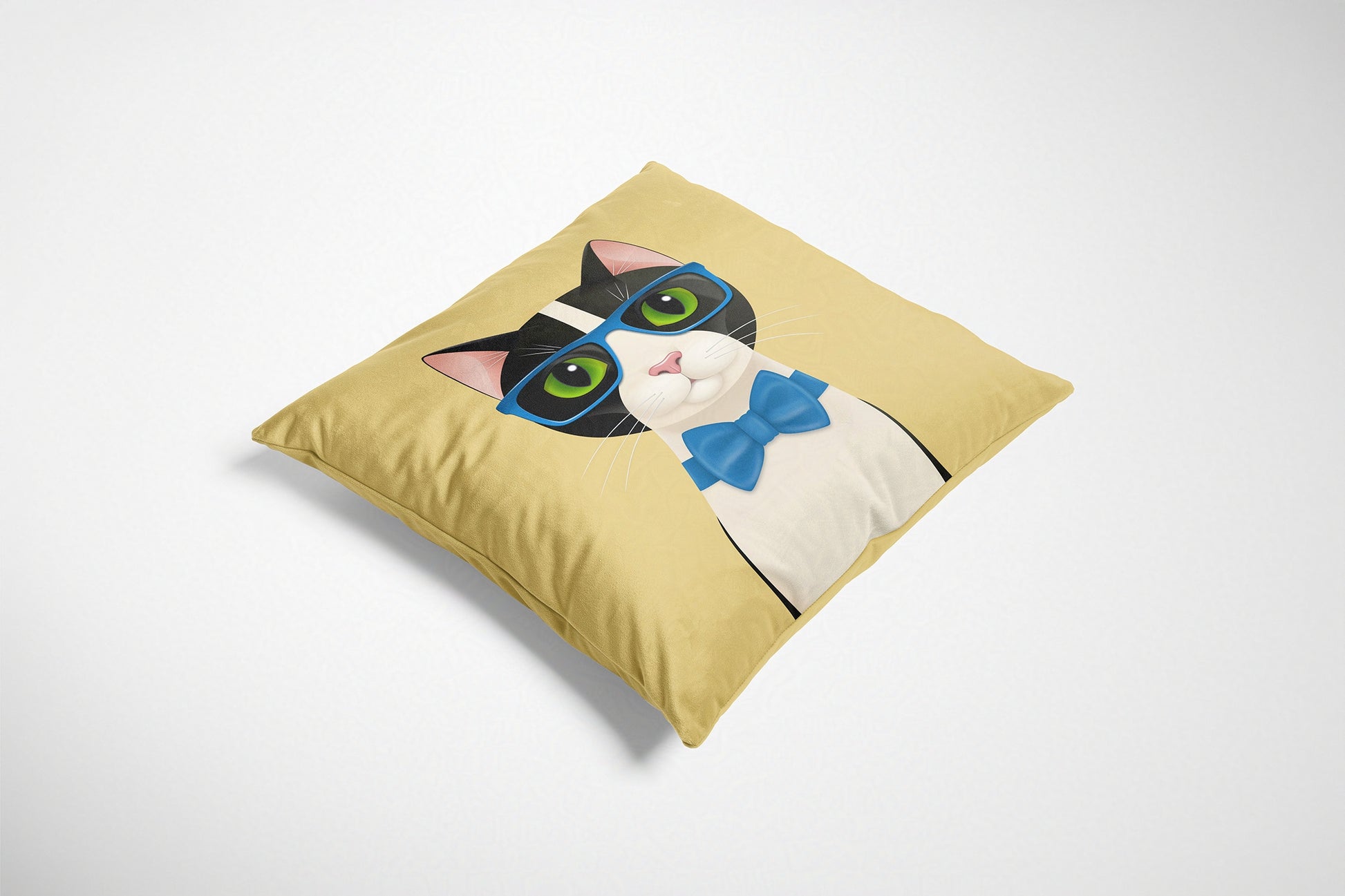 Cushion with a cat design featuring green eyes, a blue bow tie, and pink ears on a yellow background.