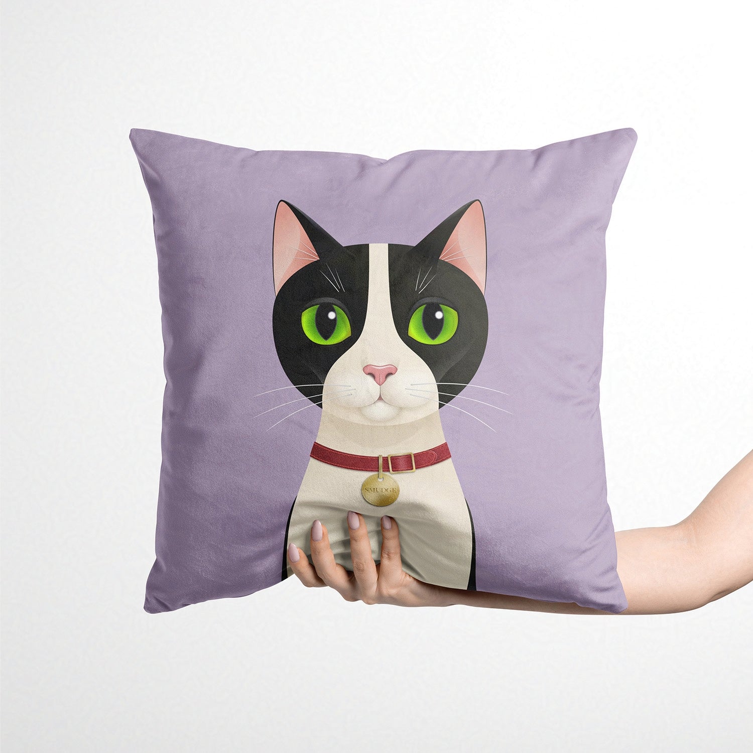 Purple cushion with a cat illustration held by a hand on a white background