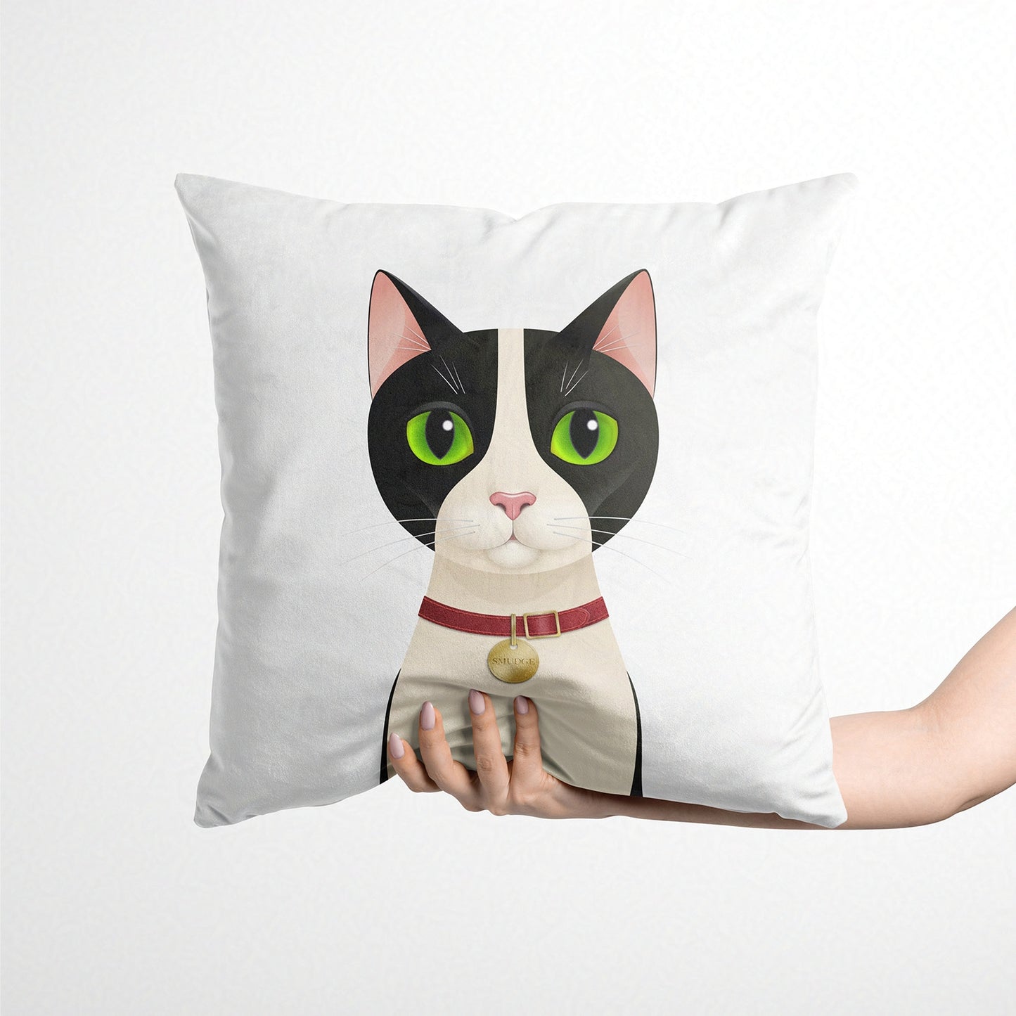 Cushion with a cat design held by a hand on a white background